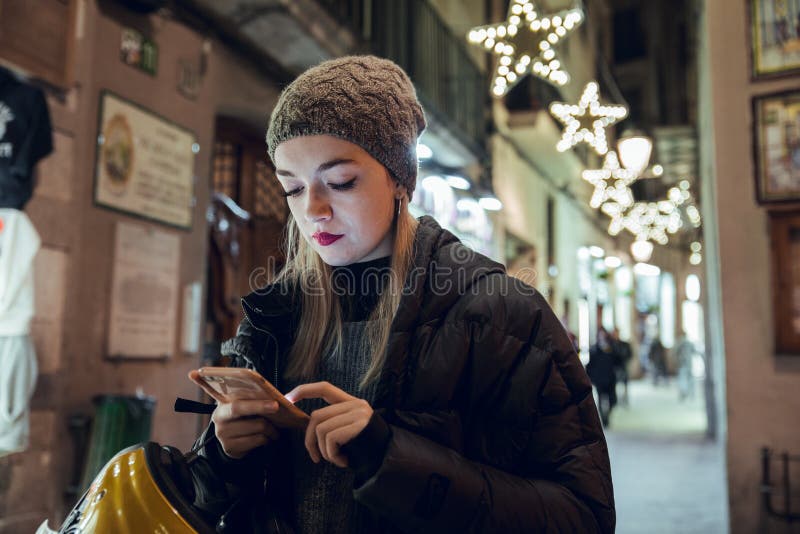 Fille blonde avec le chapeau utilisant le téléphone portable photographie stock Fille blonde avec le chapeau utilisant le téléphone portable photographie stock
