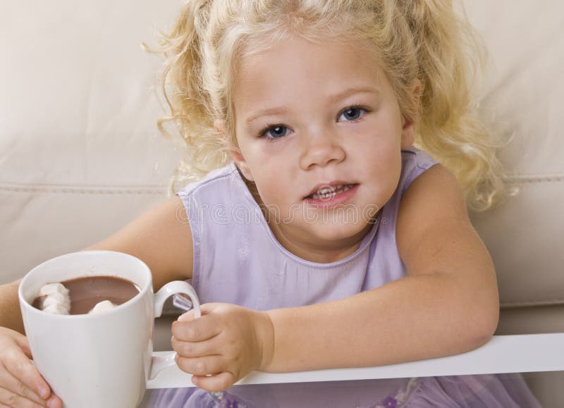 Fille buvant du chocolat chaud hors de la tasse images stock Fille buvant du chocolat chaud hors de la tasse images stock