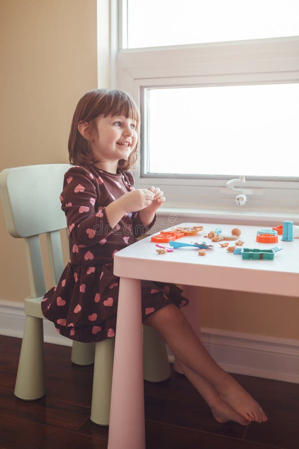 Fille caucasienne blanche d'élève du cours préparatoire jouant le playdough de pâte à modeler à l'intérieur à la maison photographie stock libre de droits Fille caucasienne blanche d'élève du cours préparatoire jouant le playdough de pâte à modeler à l'intérieur à la maison photographie stock libre de droits