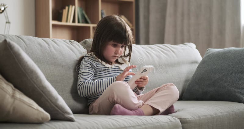 Fille concentrée avec téléphone sur le canapé salon clips vidéos