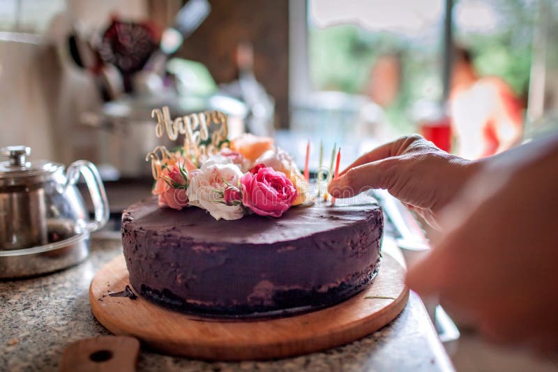 Fille célébrant son anniversaire à l'arrière-cour gâteau fait maison avec des fleurs roses fraîches image stock