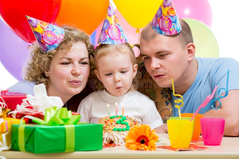 Fille d'enfant avec des bougies d'anniversaire de coup de parents photographie stock