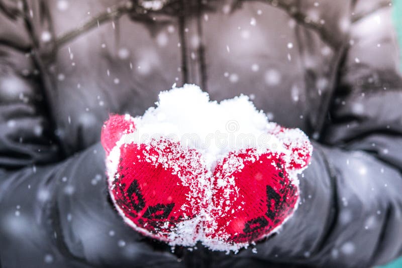 Fille Dans La Mitaine Rouge Tenant Une Poignée De Neige Image