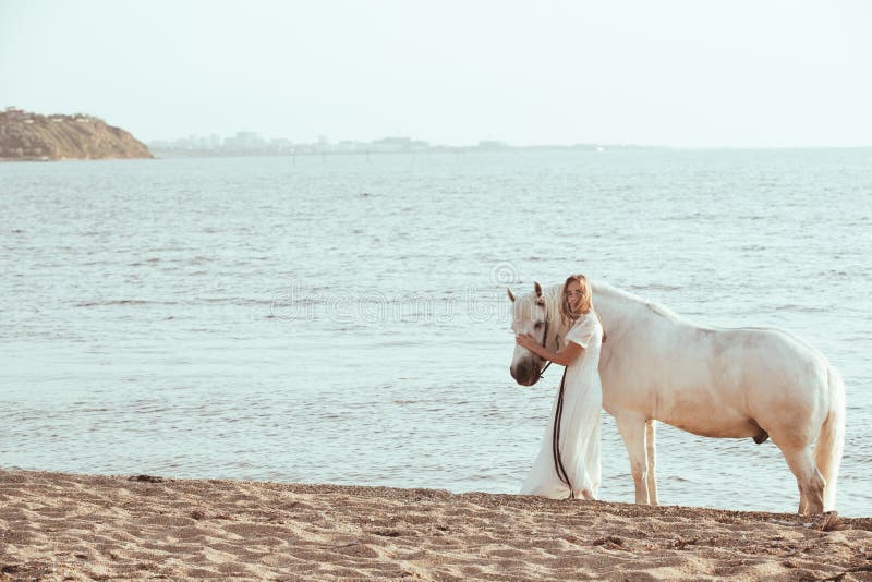 Fille Dans La Robe Blanche Avec Le Cheval Sur La Plage Image stock