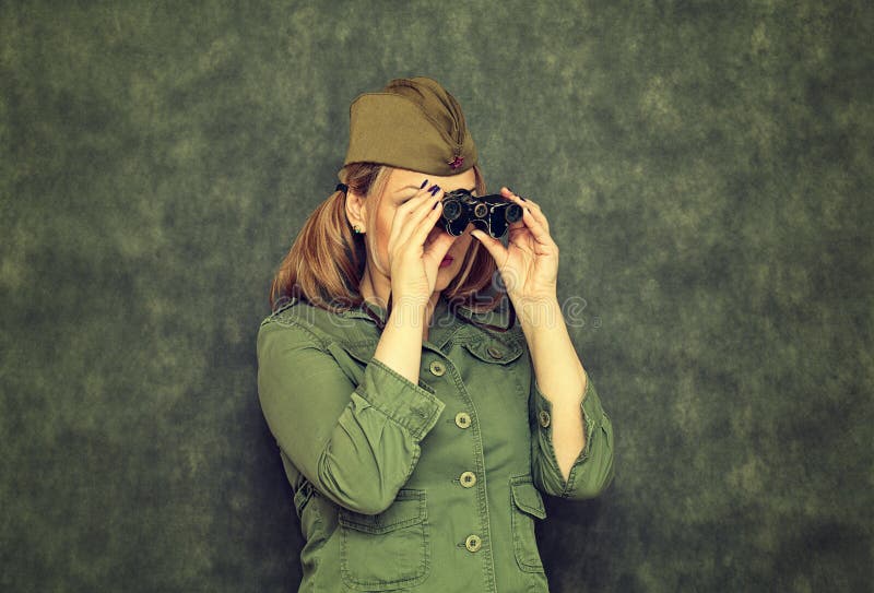 Fille dans le chapeau de garnison pendant la deuxième guerre mondiale, regardant par des jumelles images libres de droits Fille dans le chapeau de garnison pendant la deuxième guerre mondiale, regardant par des jumelles images libres de droits
