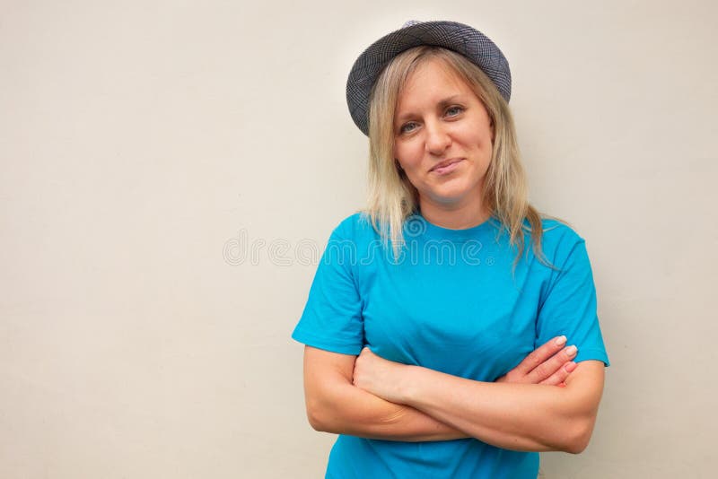 Fille dans le chapeau Le milieu blanc a vieilli des regards de femme à la caméra et croise des bras sur le portrait d'avant de se image libre de droits Fille dans le chapeau Le milieu blanc a vieilli des regards de femme à la caméra et croise des bras sur le portrait d'avant de se image libre de droits