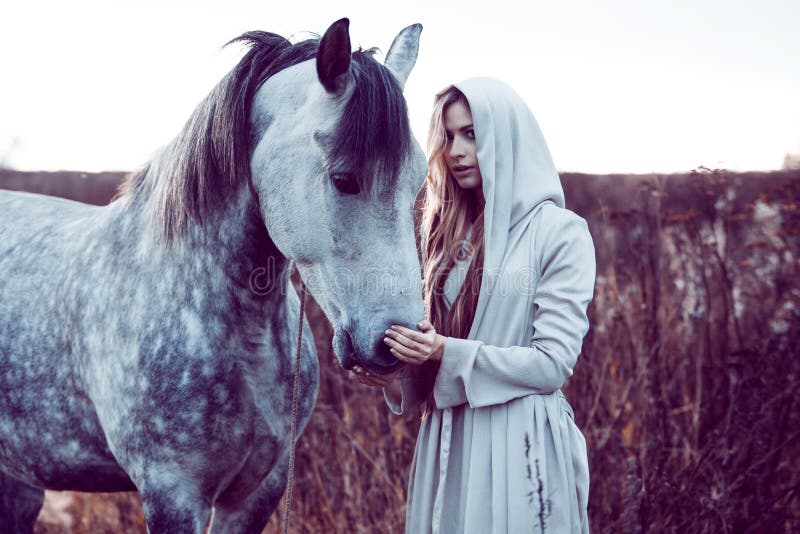 fille dans le manteau à capuchon avec le cheval, effet de la tonalité image libre de droits fille dans le manteau à capuchon avec le cheval, effet de la tonalité image libre de droits