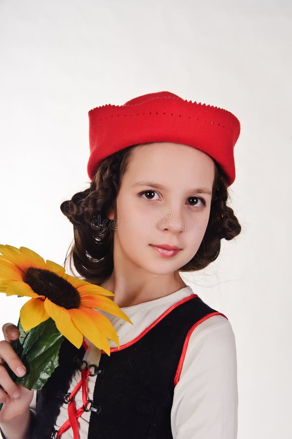 Fille dans un chapeau rouge avec un tournesol image libre de droits Fille dans un chapeau rouge avec un tournesol image libre de droits