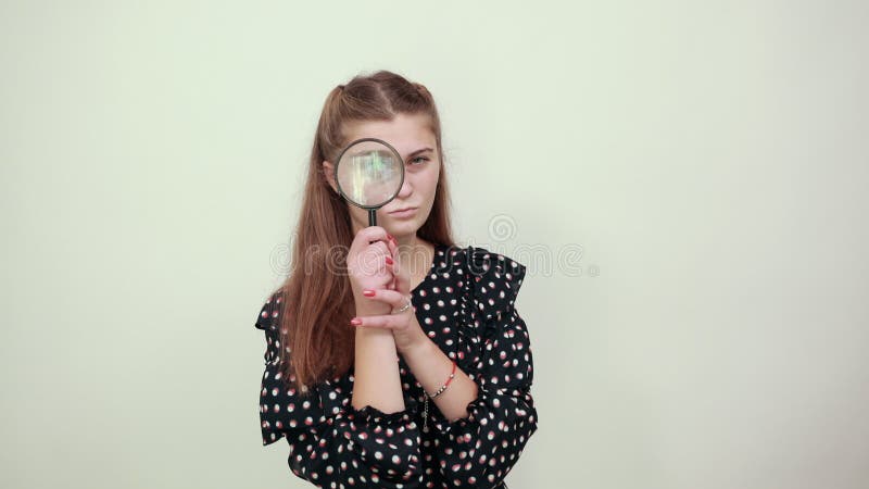 Fille dans une robe noire femme heureuse regarde à travers loupe en verre clips vidéos