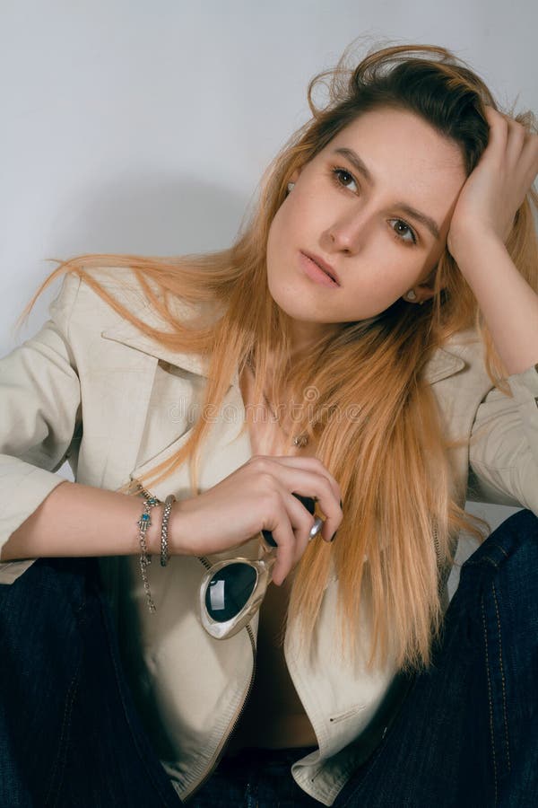 Fille dans une veste en cuir sur un fond blanc avec des verres images stock Fille dans une veste en cuir sur un fond blanc avec des verres images stock