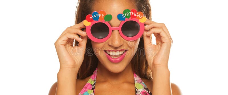 Fille de Bautiful célébrant les lunettes de soleil de port d'anniversaire sur le blanc photos libres de droits Fille de Bautiful célébrant les lunettes de soleil de port d'anniversaire sur le blanc photos libres de droits