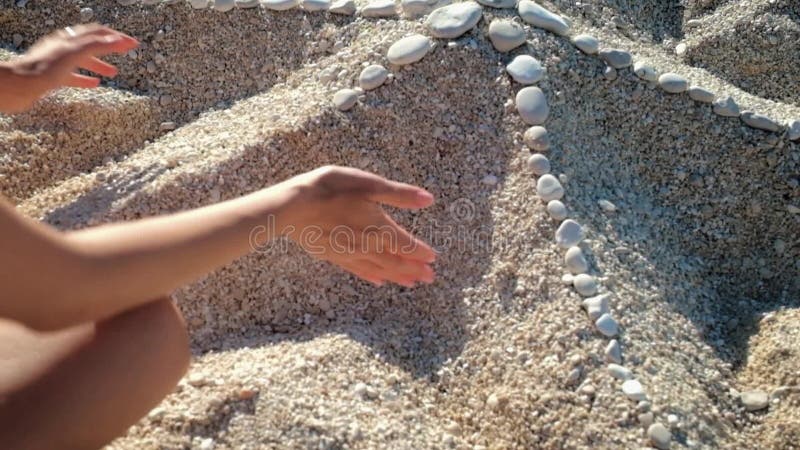 Fille de beauté faisant des étoiles de mer du sable