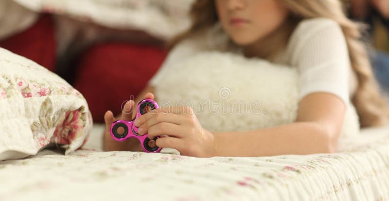Fille de jeune adolescent tenant le jouet populaire de fileur de personne remuante - le plan rapproché s'est concentré sur le fil photographie stock Fille de jeune adolescent tenant le jouet populaire de fileur de personne remuante - le plan rapproché s'est concentré sur le fil photographie stock