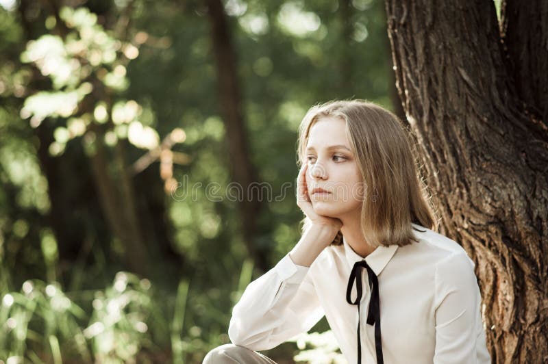 Fille de l'adolescence rêveuse dans le chemisier blanc avec le ruban noir photos stock Fille de l'adolescence rêveuse dans le chemisier blanc avec le ruban noir photos stock