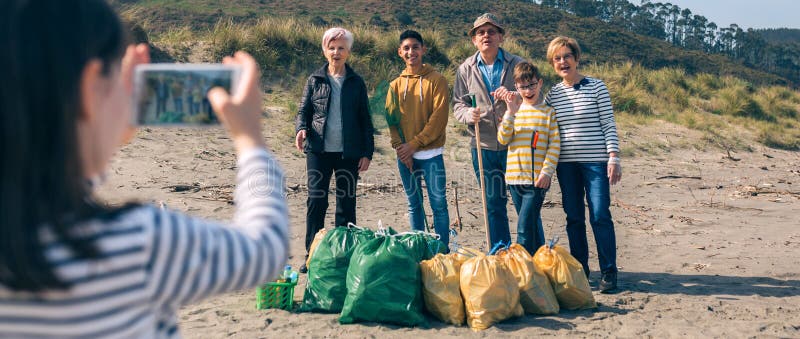Fille de la photo au groupe de volontaires après le nettoyage de la plage image stock