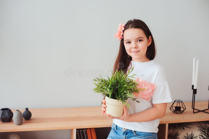 Fille de la préadolescence prenant soin des plantes d'intérieur à la maison image stock