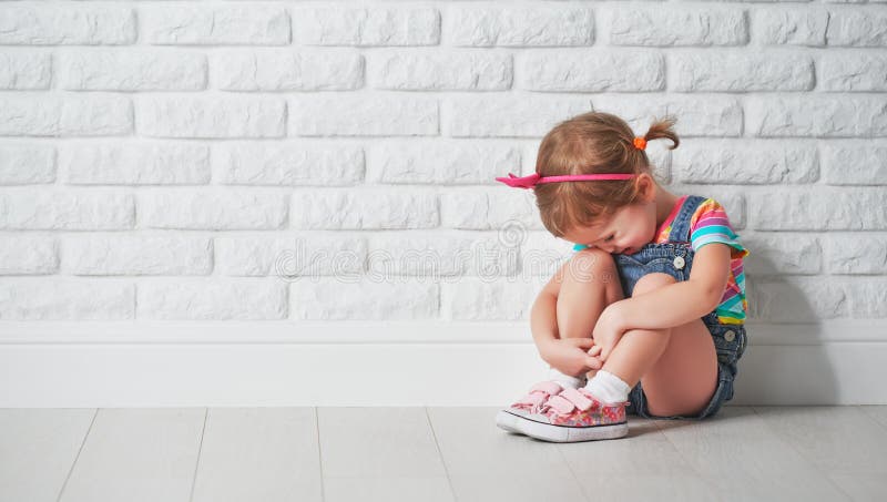 Fille de petit enfant pleurant et triste au sujet du mur de briques photo libre de droits Fille de petit enfant pleurant et triste au sujet du mur de briques photo libre de droits