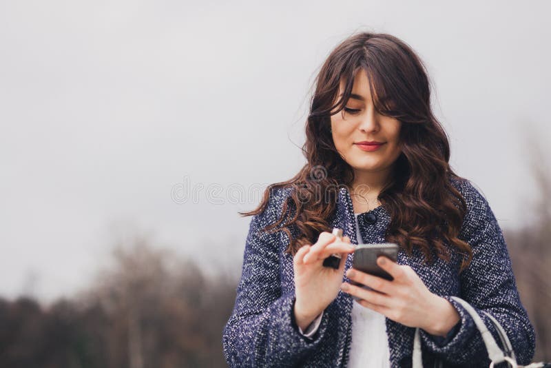 Fille de portrait de plan rapproché jeune regardant la transmission de messages de téléphone photographie stock libre de droits Fille de portrait de plan rapproché jeune regardant la transmission de messages de téléphone photographie stock libre de droits