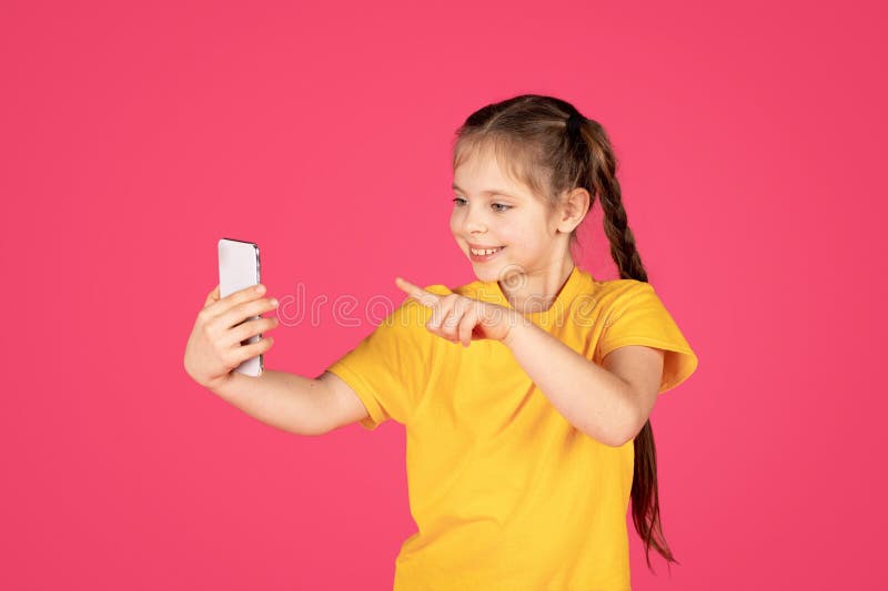 Fille de préadolescente souriante avec smartphone prenant selfie ou faisant appel vidéo photos stock