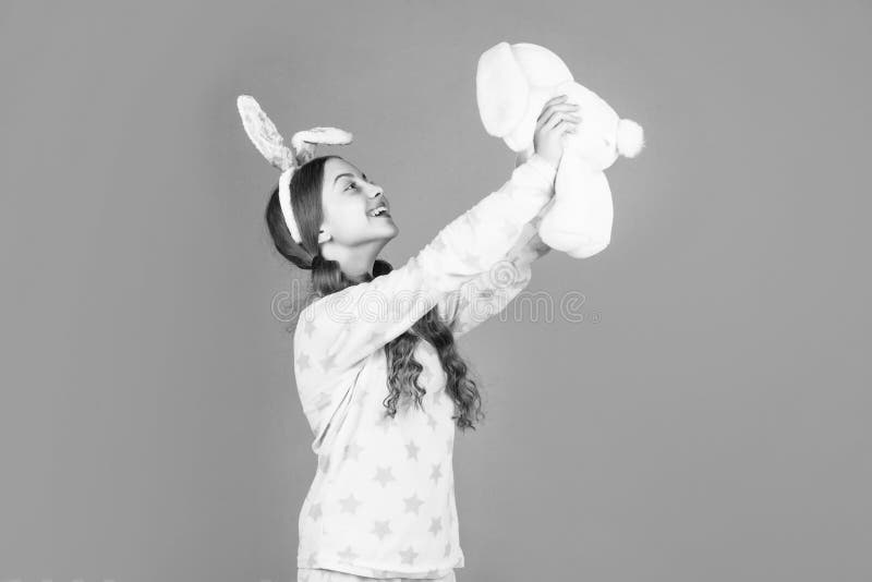 Fille de pâques heureux dans lapin lapin lapin oreilles et pyjama jouer avec jouet de pâques heureux photo stock