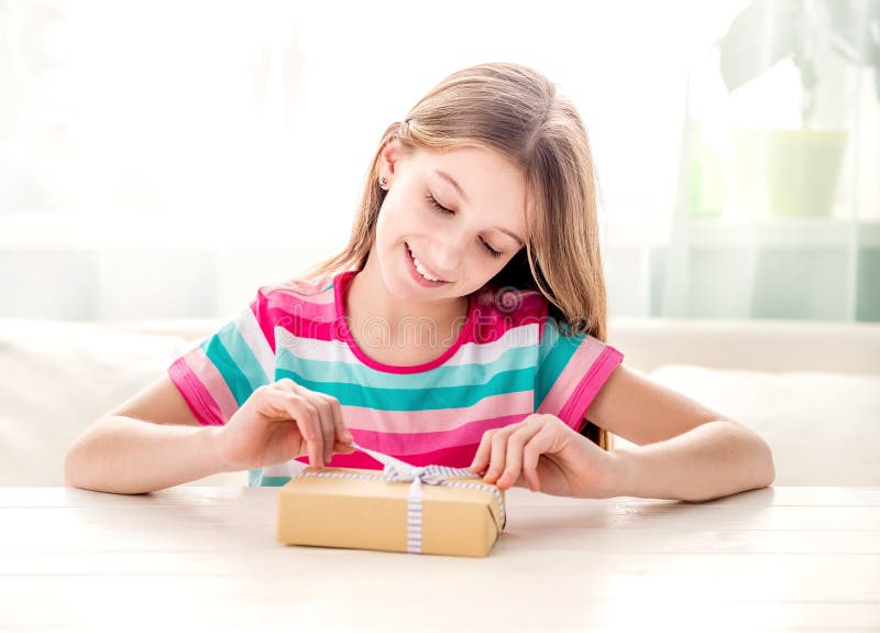 Fille de sourire déroulant la boîte actuelle images libres de droits Fille de sourire déroulant la boîte actuelle images libres de droits