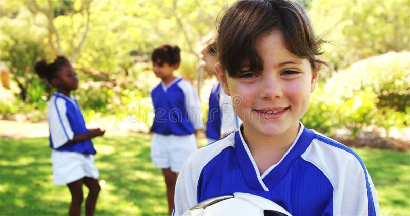 Fille de sourire tenant un football en parc banque de vidéos