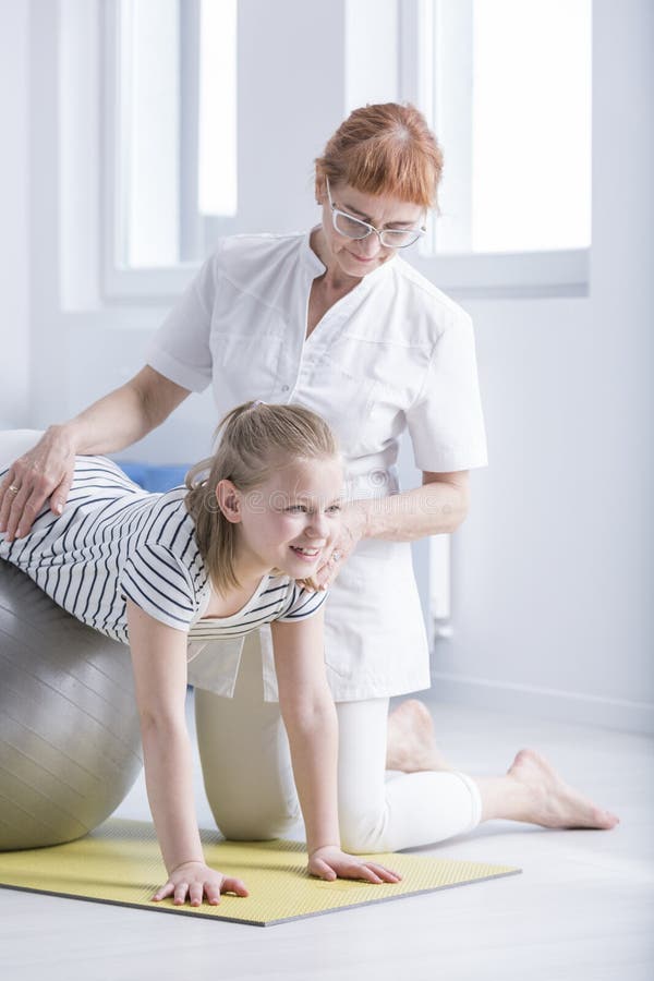 Fille de soutien de physiothérapeute avec la scoliose photos stock Fille de soutien de physiothérapeute avec la scoliose photos stock