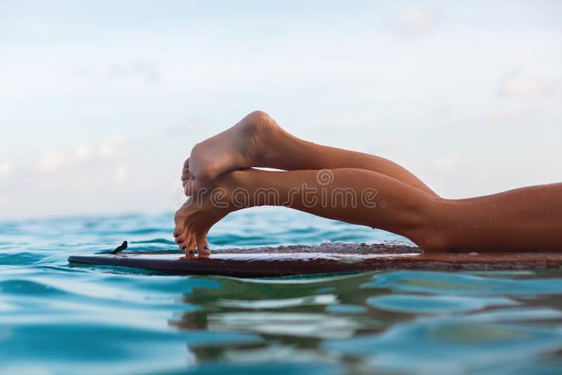 Fille de surfer se trouvant sur la planche de surf image stock
