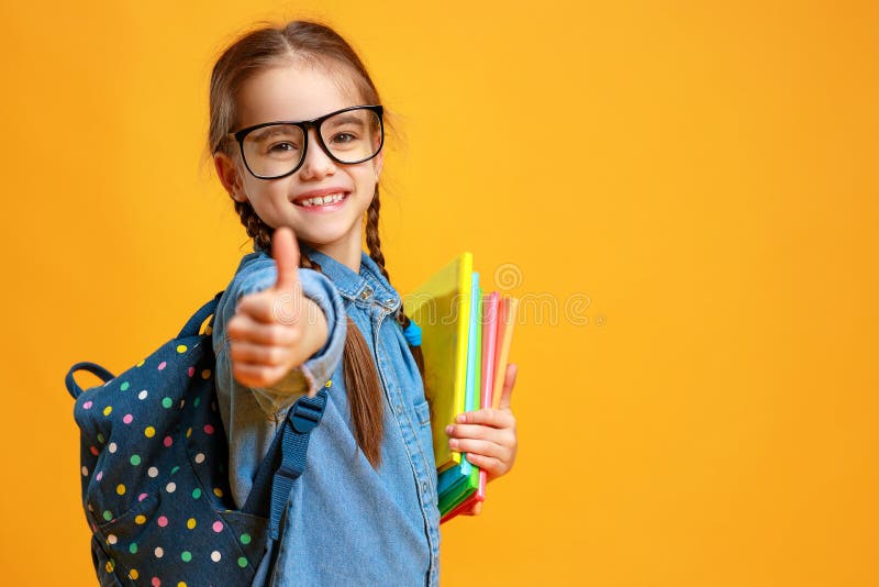 Fille dr?le de fille d'?cole d'enfant sur le fond jaune images stock Fille dr?le de fille d'?cole d'enfant sur le fond jaune images stock