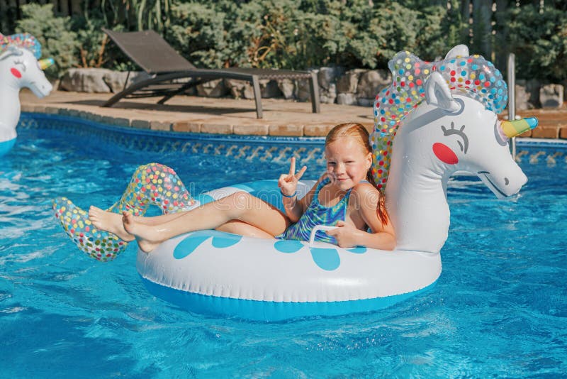 Jolie Fille Rousse Plongeant Dans La Piscine Depuis Le Tremplin. Enfant  Enfant S'amusant Dans La Piscine De La Cour Arrière De La Maison. Activité  Aquatique D'été En Plein Air Pour Les Enfants.