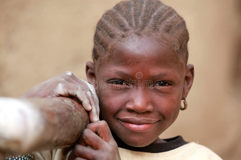 Girl in Africa carrying a pole to mould grain. Girl in Africa carrying a pole to mould grain