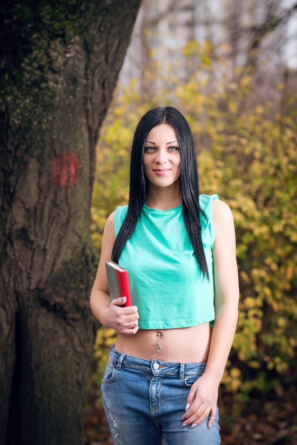 Fille en parc tenant le livre photos stock Fille en parc tenant le livre photos stock