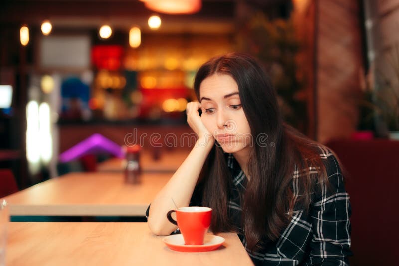 Fille ennuyée attendant sa date dans un café photo libre de droits Fille ennuyée attendant sa date dans un café photo libre de droits