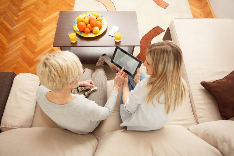 Fille enseignant à la mère aînée comment utiliser une tablette. Vue en angle élevé photos libres de droits Fille enseignant à la mère aînée comment utiliser une tablette. Vue en angle élevé photos libres de droits