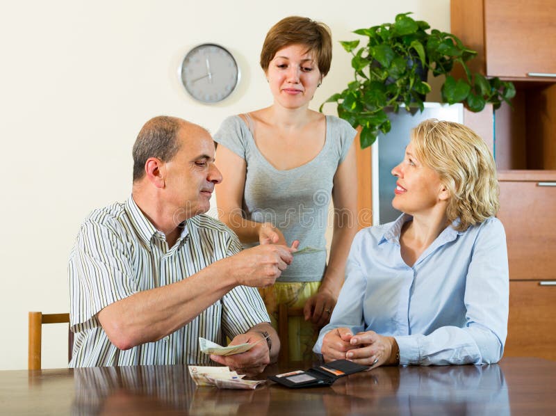 Fille et parents adultes avec l'argent photos libres de droits Fille et parents adultes avec l'argent photos libres de droits