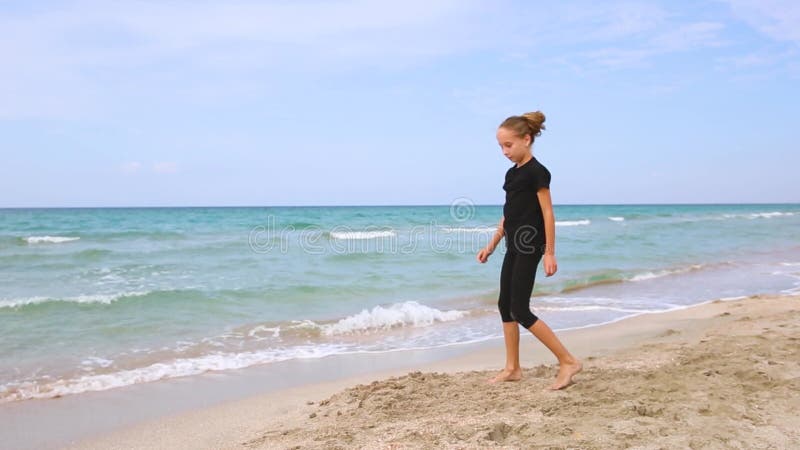 Fille faisant de la gymnastique sur la plage. banque de vidéos