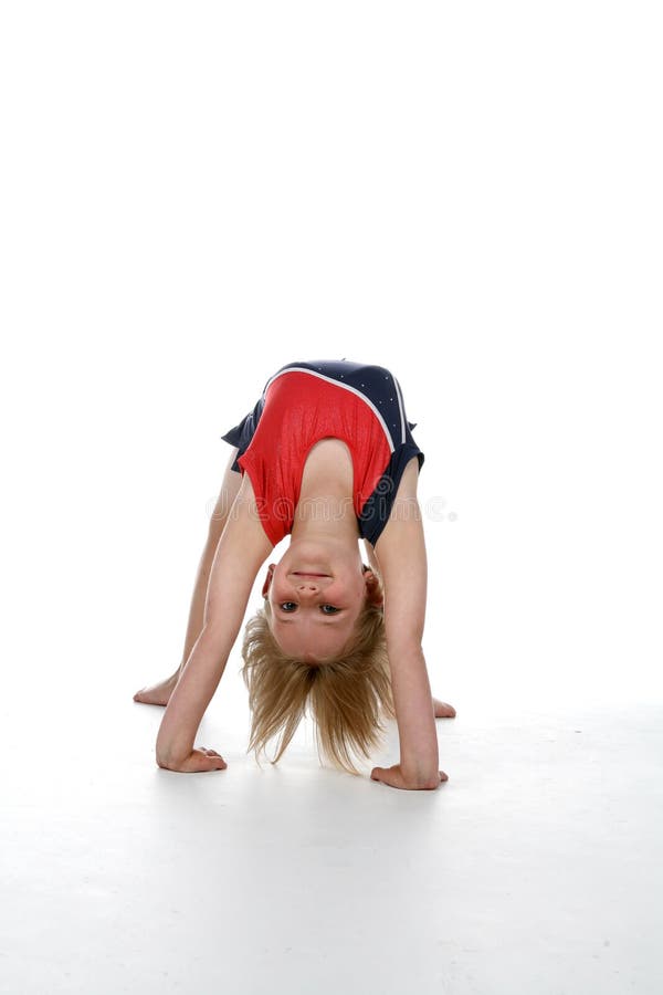 Fille faisant une position de passerelle de gymnastique image libre de droits Fille faisant une position de passerelle de gymnastique image libre de droits