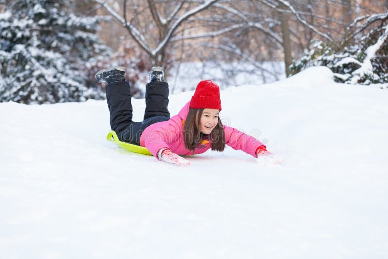 Fille glissant sur la neige de la colline rapidement images stock Fille glissant sur la neige de la colline rapidement images stock