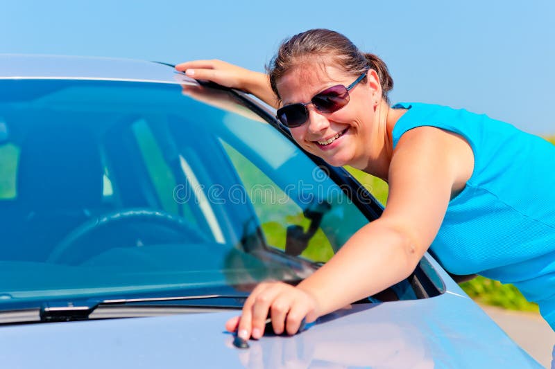 Fille heureuse embrassant sa nouvelle voiture photographie stock libre de droits Fille heureuse embrassant sa nouvelle voiture photographie stock libre de droits