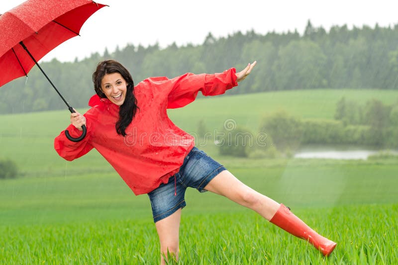 Fille heureuse espiègle sous la pluie image libre de droits Fille heureuse espiègle sous la pluie image libre de droits
