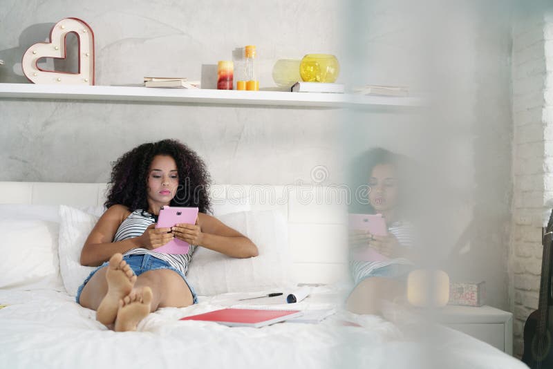 Fille hispanique à l'aide de la Tablette de Digital pour des devoirs d'école photographie stock libre de droits Fille hispanique à l'aide de la Tablette de Digital pour des devoirs d'école photographie stock libre de droits