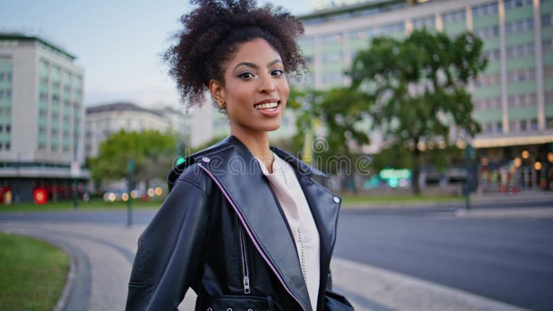 Fille insouciante debout place urbaine regarder devant closeuse. modèle africain à la mode banque de vidéos