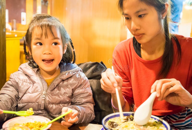 Fille japonaise de alimentation images libres de droits Fille japonaise de alimentation images libres de droits