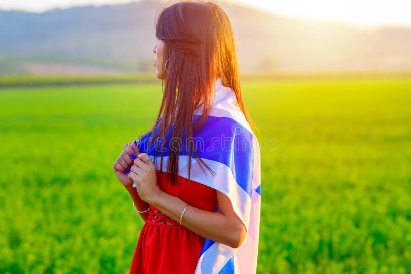 Fille juive avec le drapeau de l'Isra?l sur le paysage stup?fiant en bel ?t? photo libre de droits Fille juive avec le drapeau de l'Isra?l sur le paysage stup?fiant en bel ?t? photo libre de droits