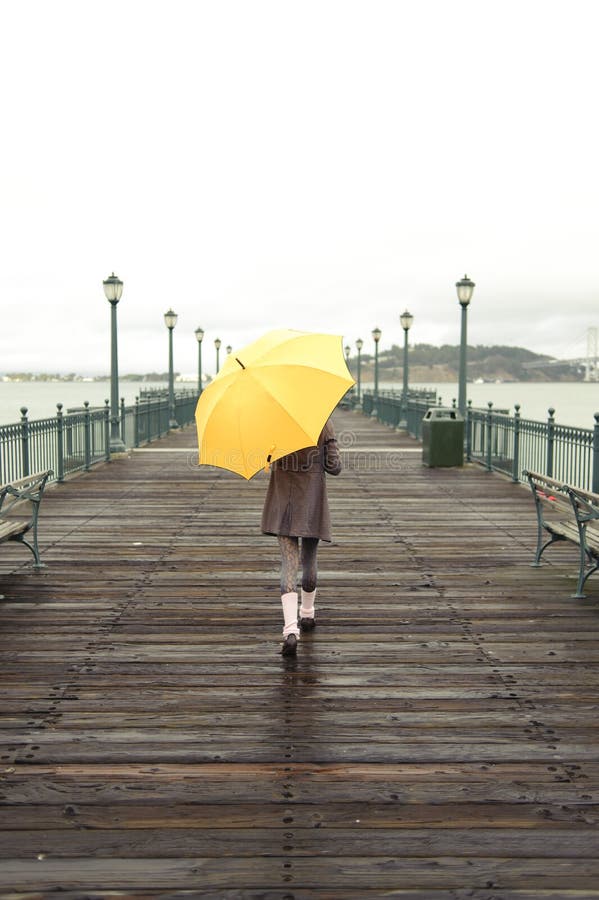 Fille marchant avec le parapluie images stock Fille marchant avec le parapluie images stock
