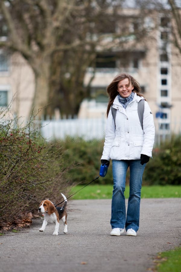 Girl walking with her dog on the leash. Beagle puppy. Girl walking with her dog on the leash. Beagle puppy