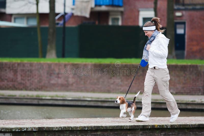 Girl walking with her dog on the leash. Beagle puppy. Girl walking with her dog on the leash. Beagle puppy