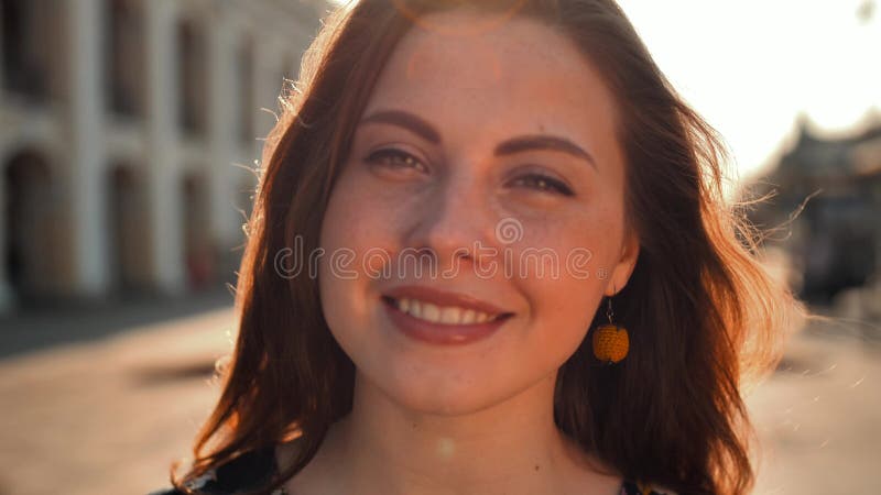 Fille mignonne avec les cheveux et les taches de rousseur rouges sur la rue Grande rue de central de ville Éclairage de lever de