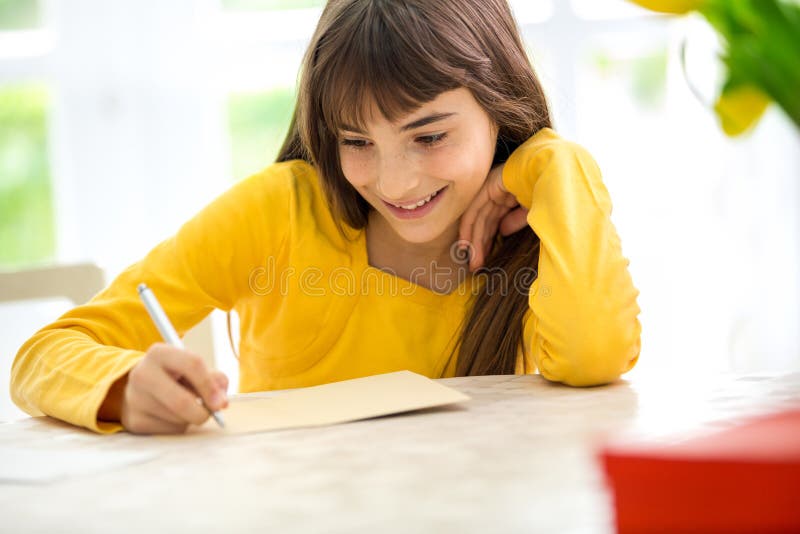 Fille mignonne écrivant une lettre photographie stock Fille mignonne écrivant une lettre photographie stock