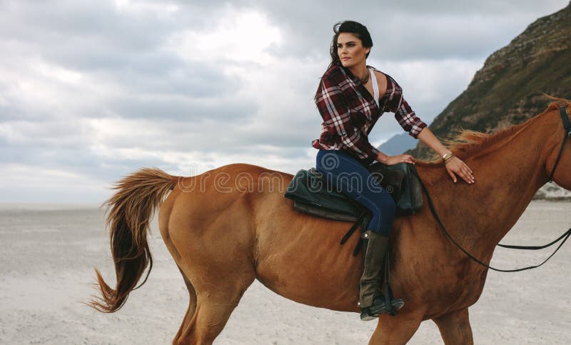 Fille montant un cheval sur le littoral images libres de droits Fille montant un cheval sur le littoral images libres de droits